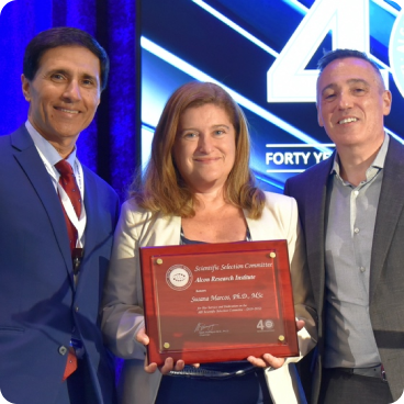 A group of individials showcasing an award recipient