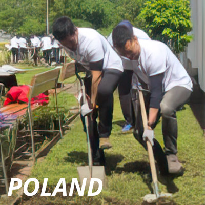 Two Alcon volunteers in Poland doing landscaping work