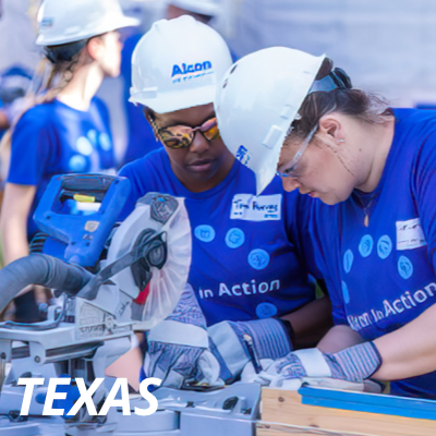Alcon volunteers in Texas wearing hardhats, working with construction equipment