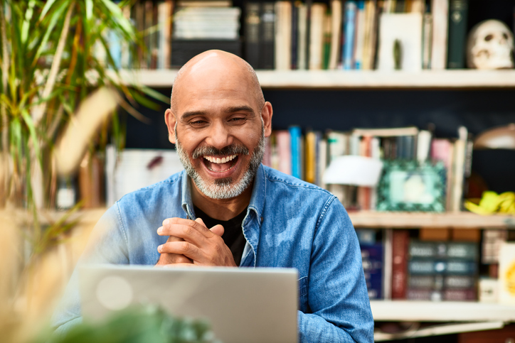 Man smiling and looking at laptop