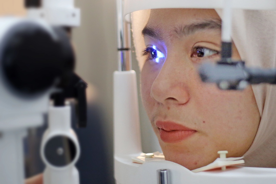 Woman having eye scanned during examination