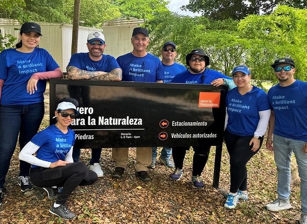 Employees gathered around a park sign.