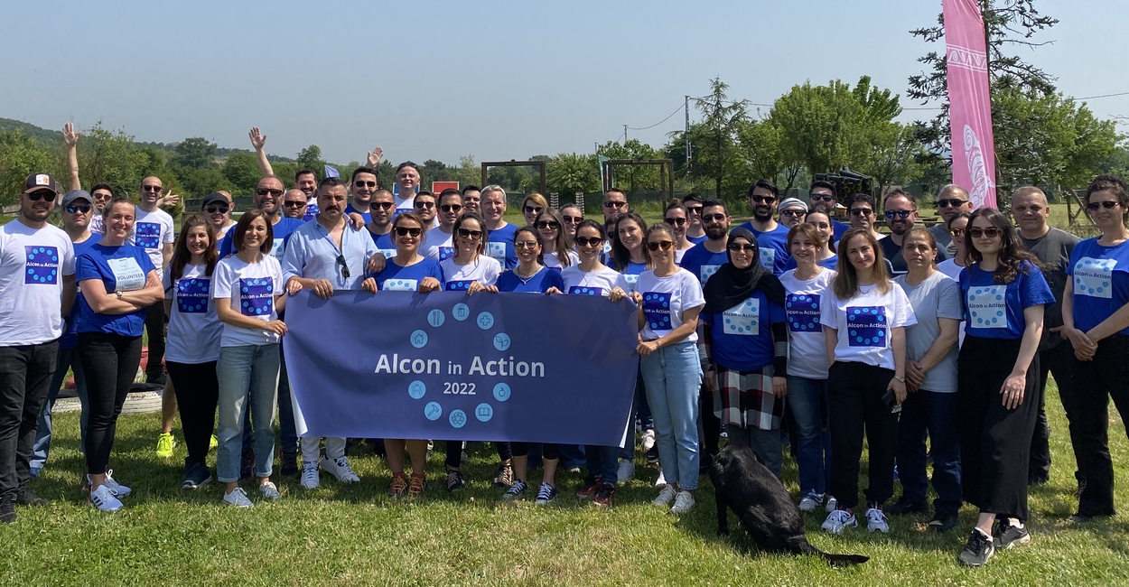 Alcon employees standing with banner