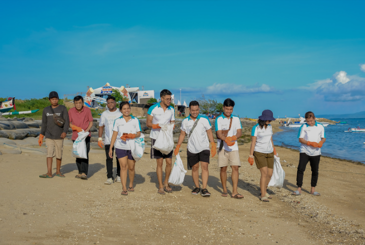 Group of people collecting plastic on beach