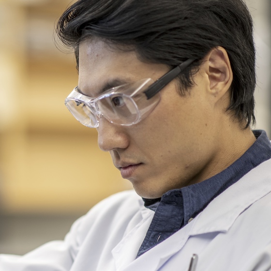 Close-up of man wearing a lab coat and goggles